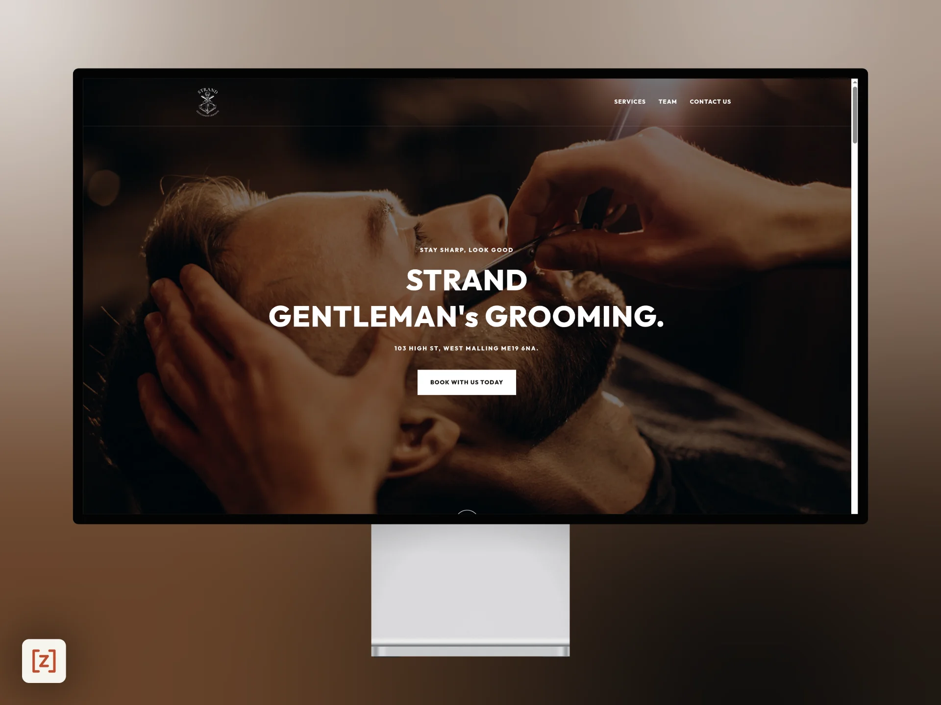 Strand Gentleman’s Grooming website on a desktop monitor, showing the West Malling homepage and booking button.